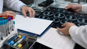 Clinical researchers arranging imaging notes laboratory samples and waveform evidence